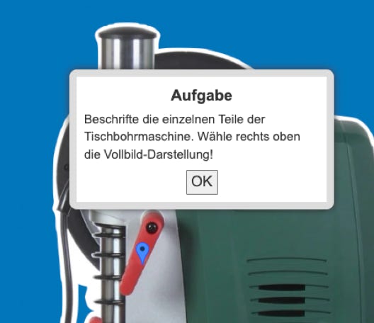 Ein Dialogfenster mit der Aufgabe, Teile einer Tischbohrmaschine zu beschriften, überlagert das Bild einer Maschine vor blauem Hintergrund.